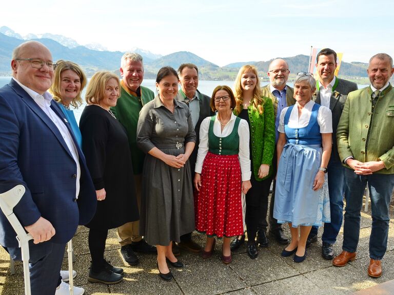 Personengruppe im feschen Trachengewand, fotografiert vor Bergen und See