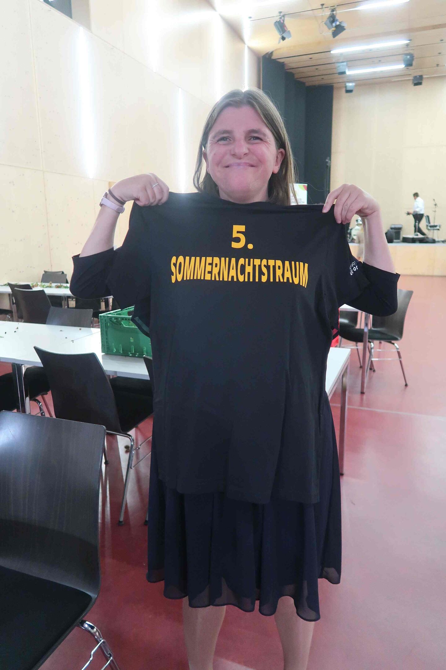 Frau hält TShirt hoch, auf dem steht: 5. Sommernachtstraum