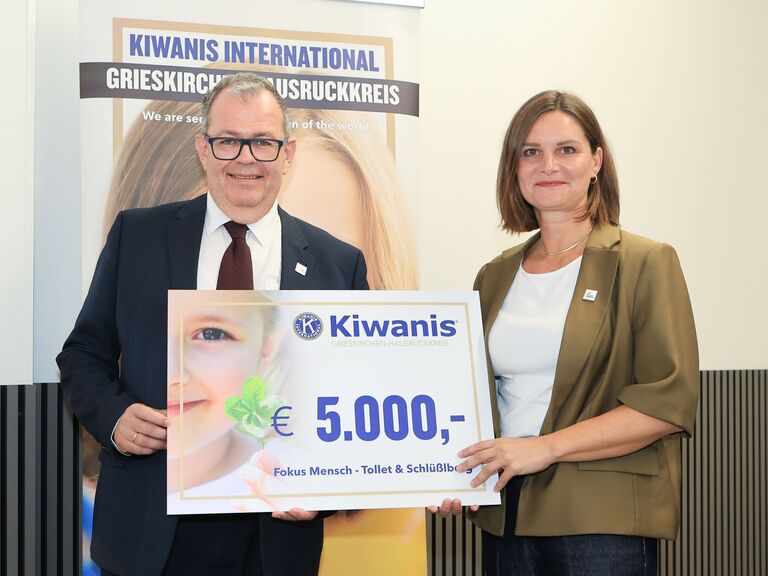 Michael LEitner und Christine Krenn halten symbolischen Scheck über 5000 Euro in die Kamera und lächeln