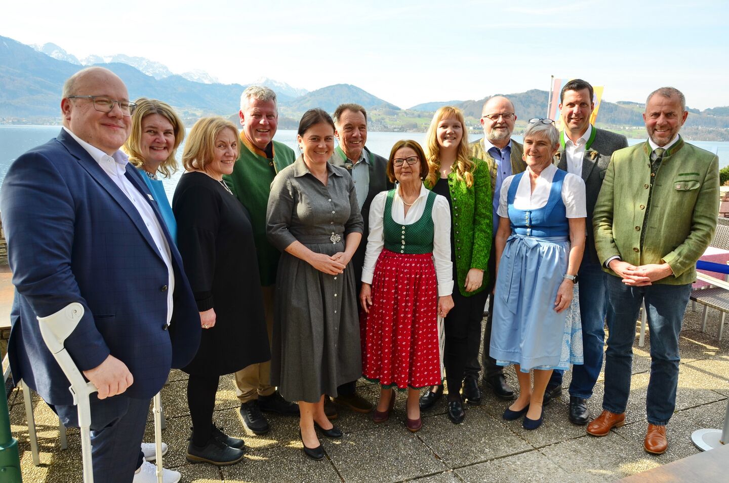 Personengruppe im feschen Trachengewand, fotografiert vor Bergen und See
