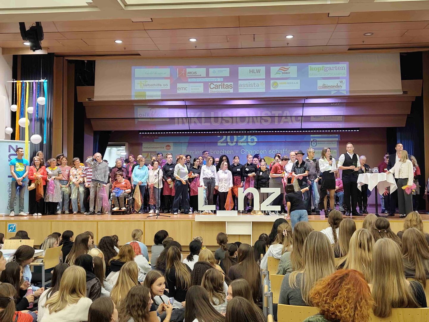 großes Gruppenfoto mit vielen Personen auf der Bühne