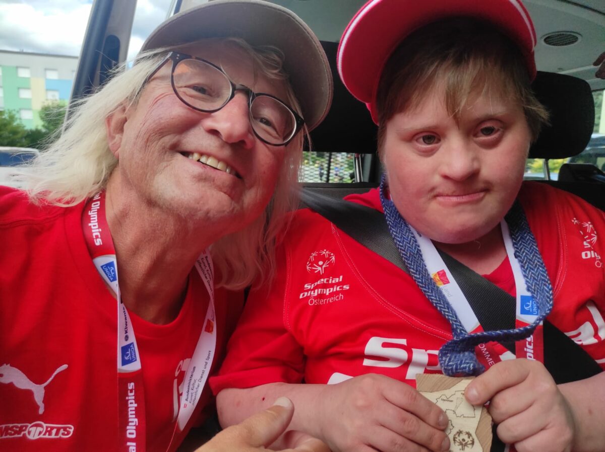 Teilnehmer und Fan lächeln glücklich in die Kamera