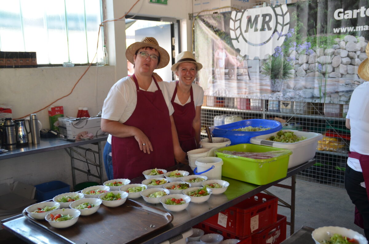 zwei Frauen befüllen kleine Salatschüsseln