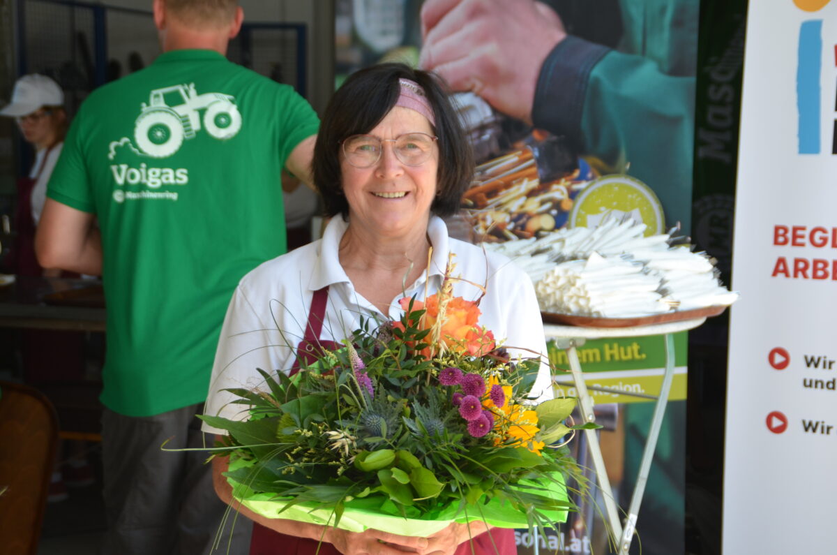 Frau mit Blumenstrauß lächelt in die Kamera