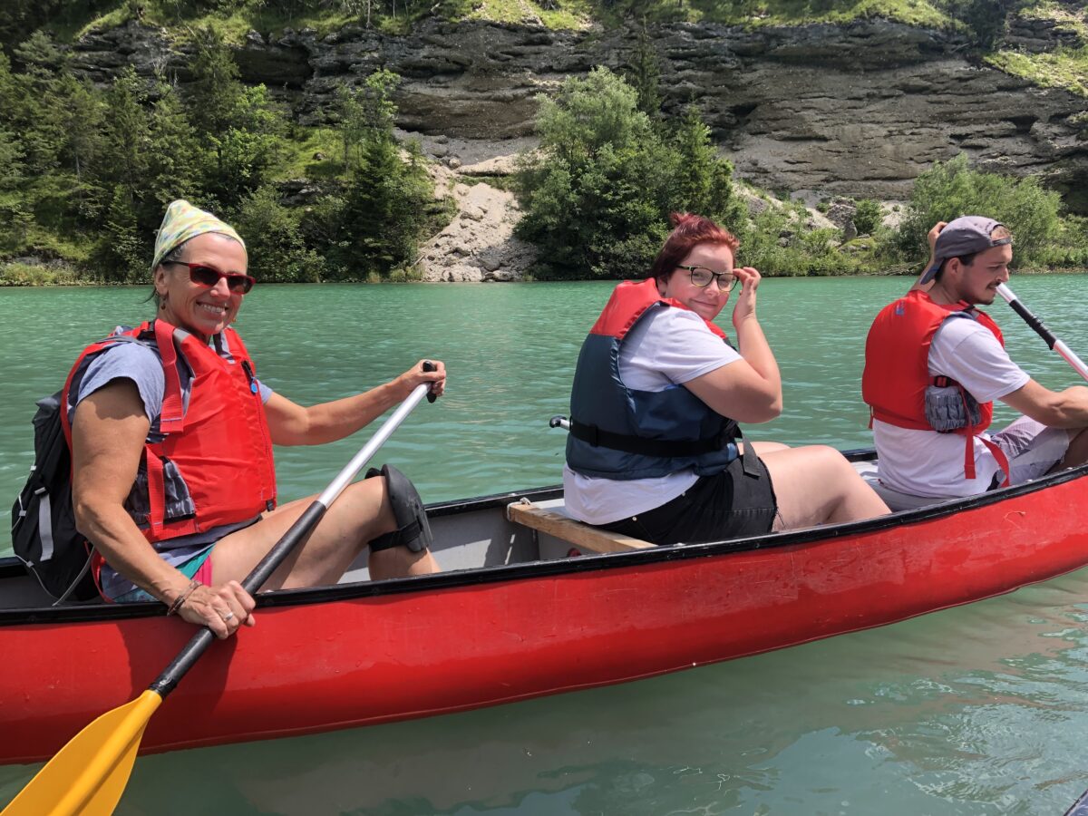 drei Menschen im Paddelboot auf dem Wasser