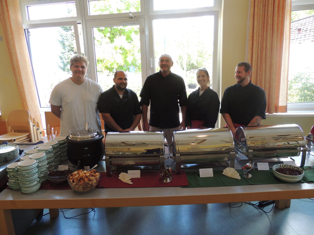 Küchenteam steht hinter Warmhalte-Serviergeschirr