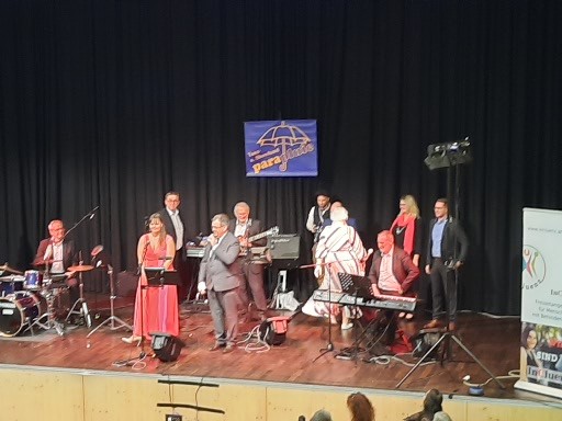Musikband auf der Bühne mit Rednerinnen und Redner