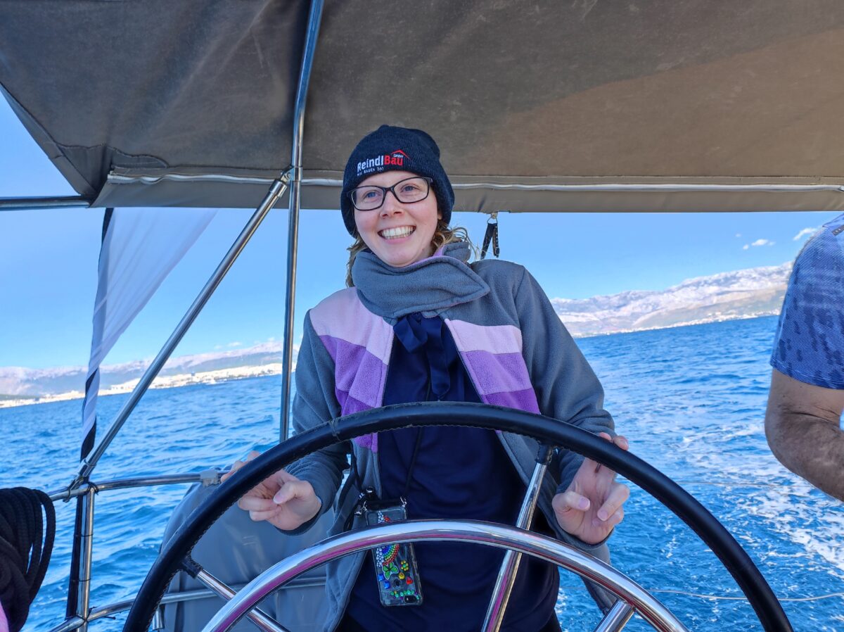 junge Frau am Steuerrad eines Schiffes