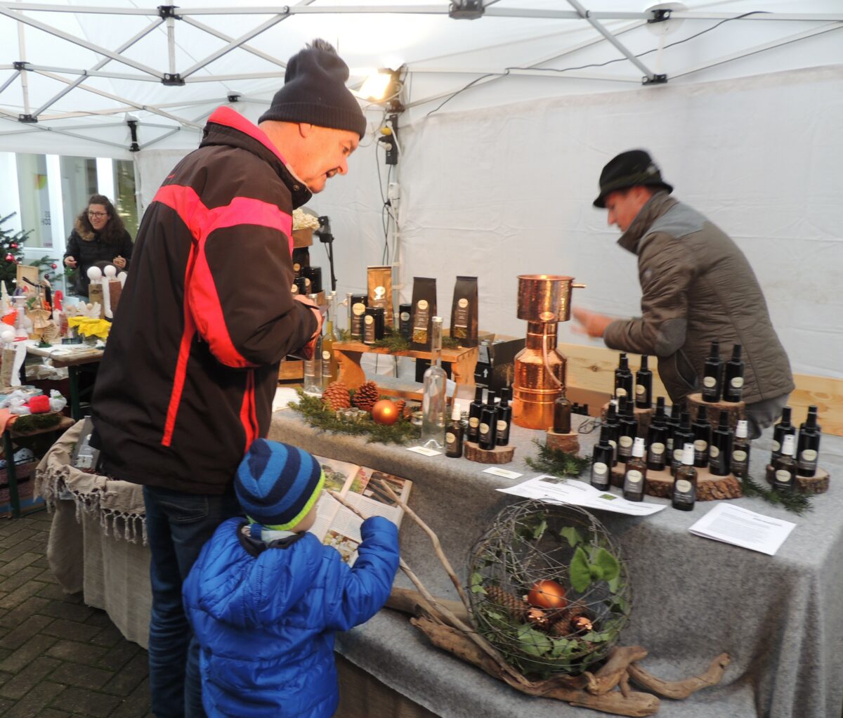 Weihnachtsmarktbesucher (Mann mit Kind) beim Standl