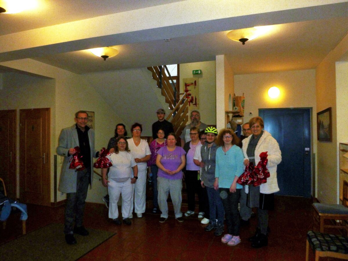 Gruppe von Menschen, manche halten ein rotes Nikolaus-Sackerl