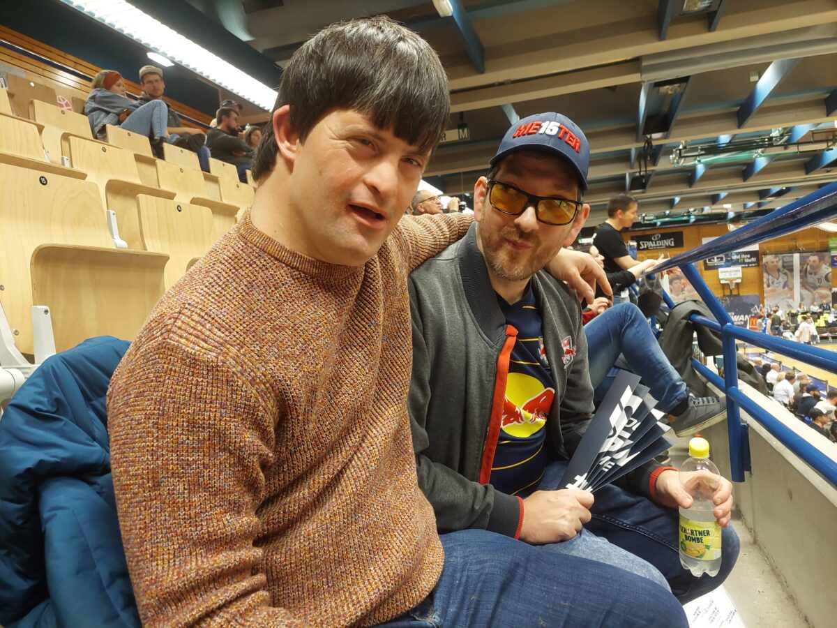 zwei männliche Fans sitzen in der Tribüne