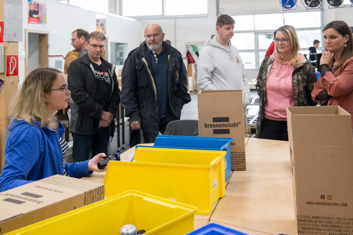 junge Frau erklärt Arbeit in der Werkstatt