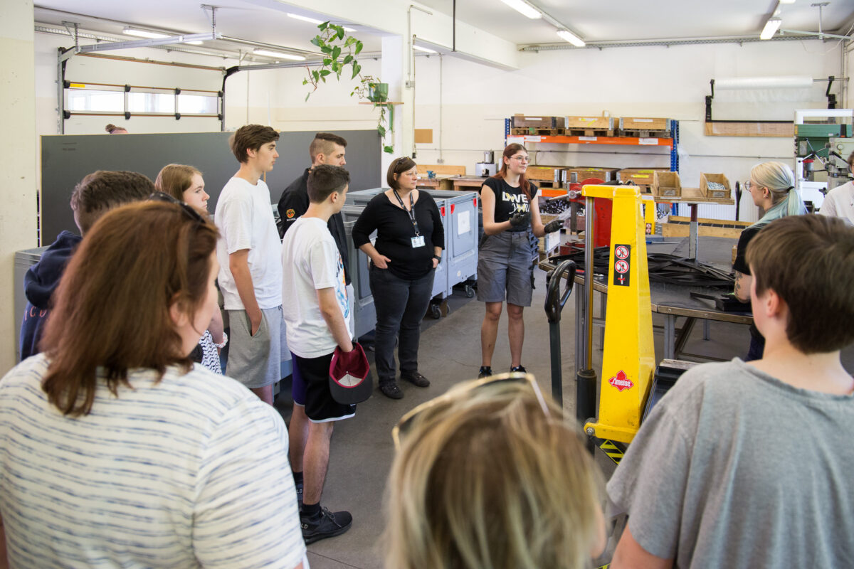 Gruppe junger Menschen bei einer Werkstatts-Besichtigung