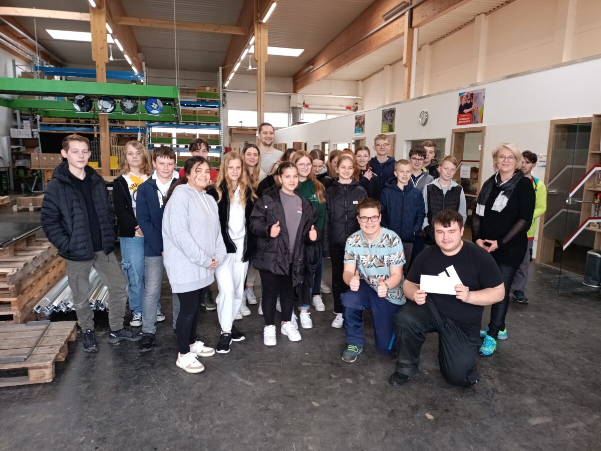 Gruppenbild von jungen Menschen in einer Betriebswerkstatt