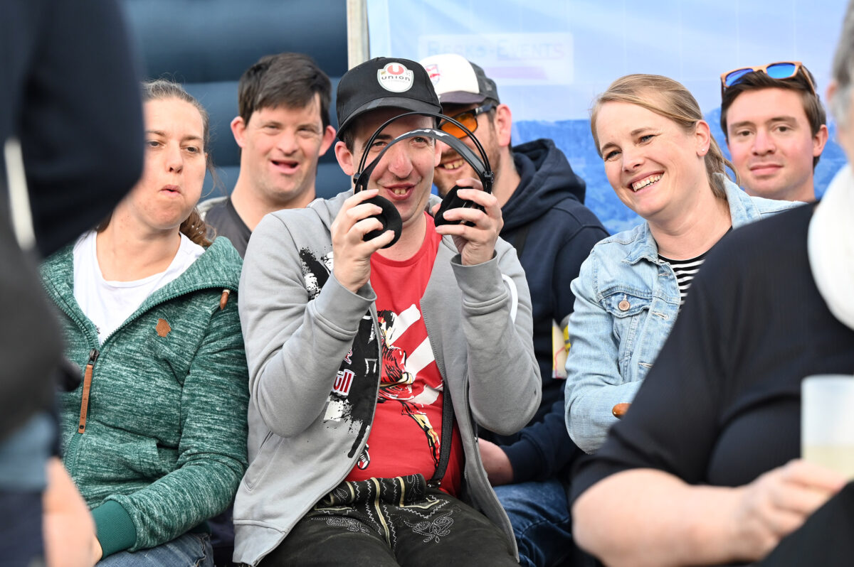 Fan mit Kopfhörern, in der Gruppe sitzend