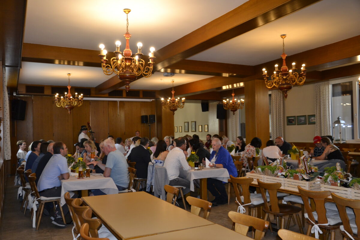 Gruppe von Festgästen an langen Esstischen