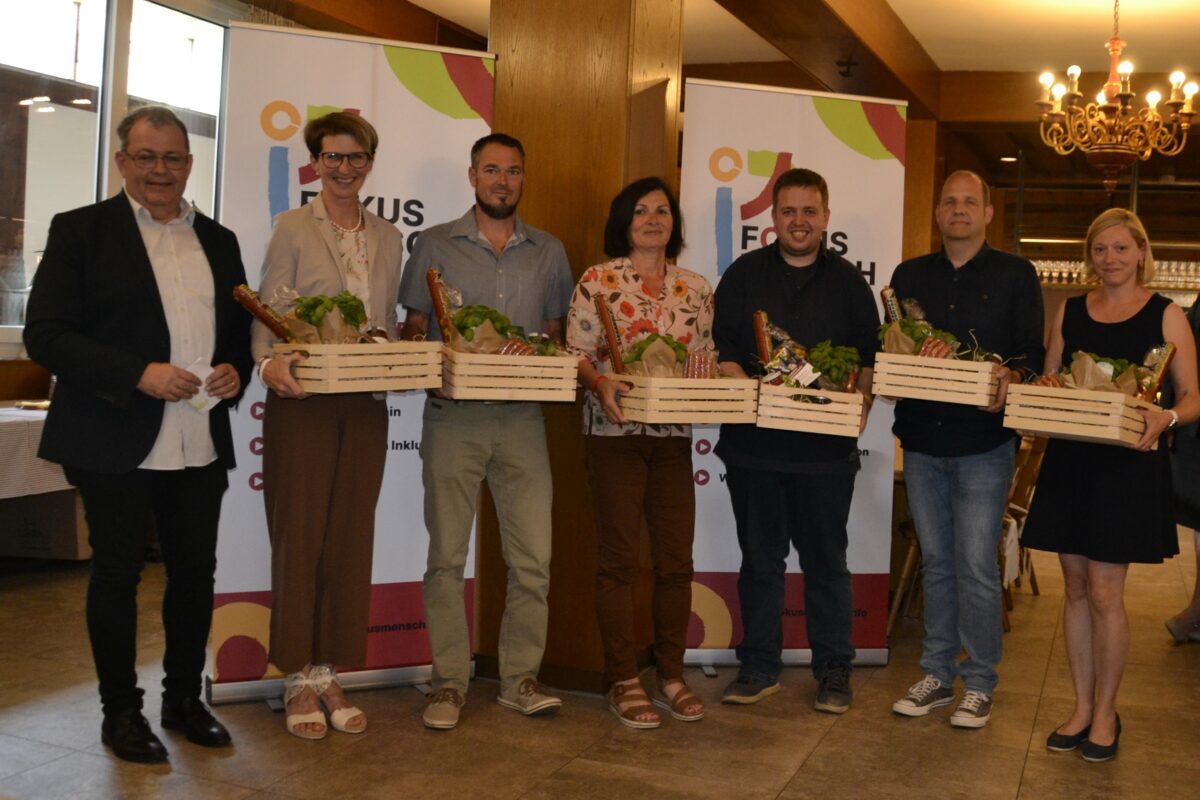 Ehrung langjähriger Mitarbeiterinnen und Mitarbeiter - Gruppenfoto mit Geschenkkörben