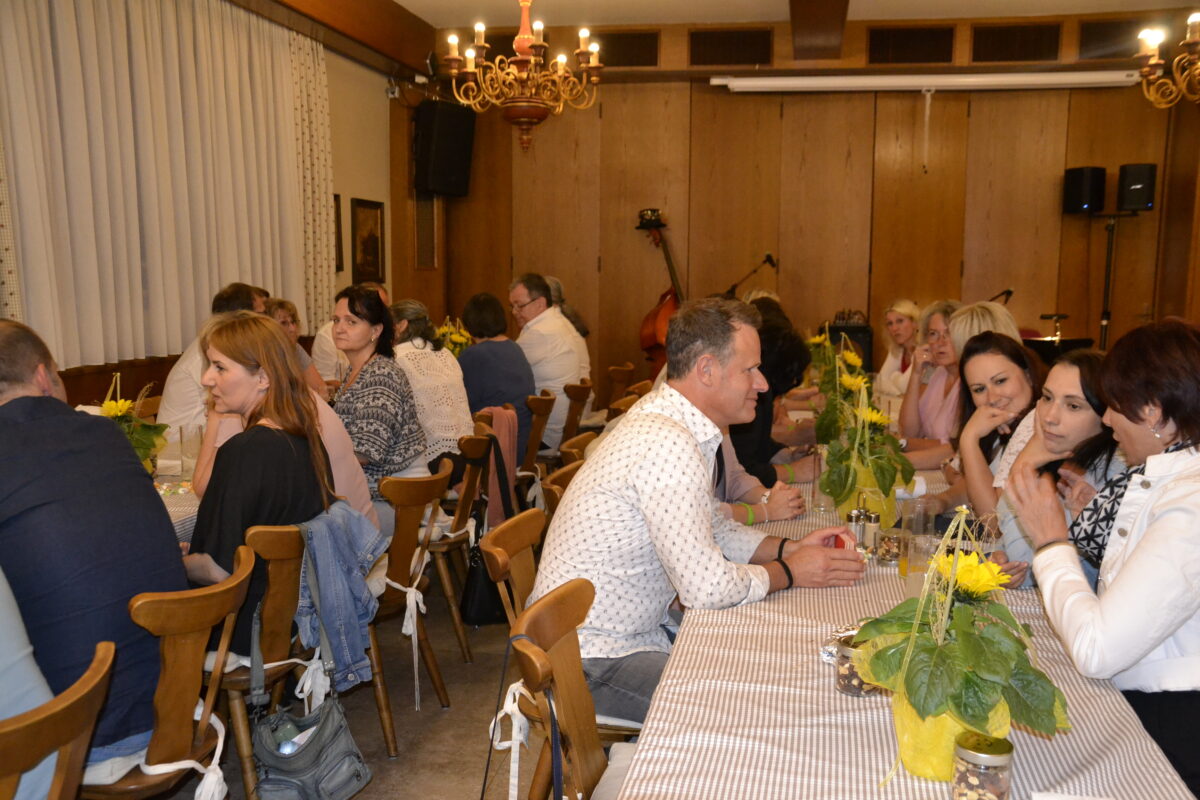 Gruppe Menschen bei langen Esstischen