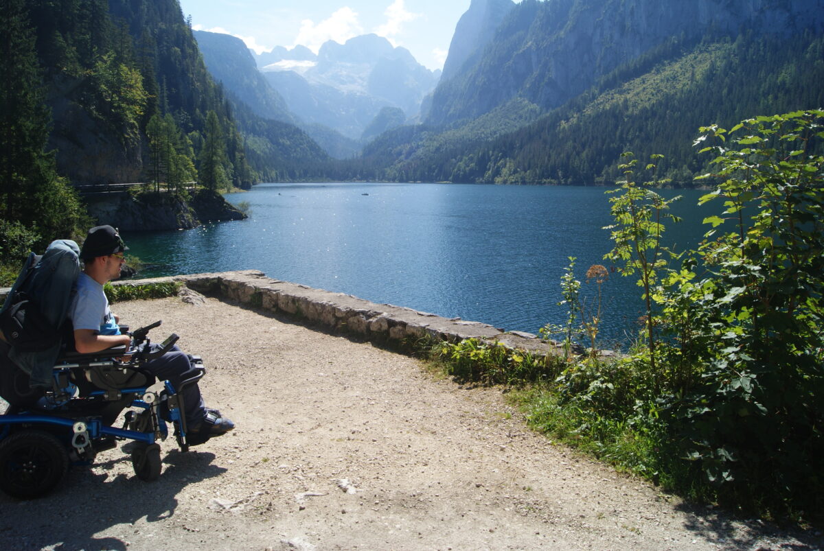 Mann im Rollstuhl auf Aussichtsstelle, blickt auf Vorderen Gosausee