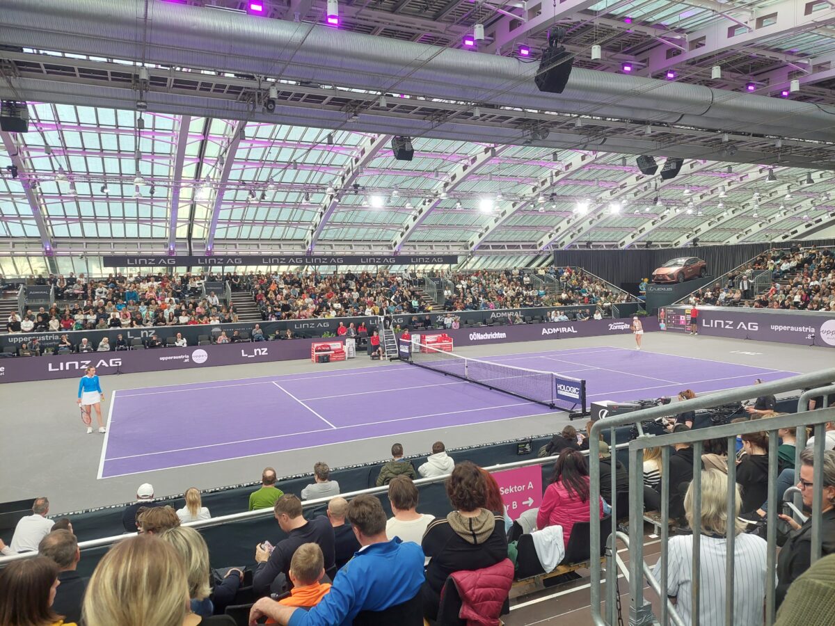 voll besetzte Besuchertribüne in einer Tennishalle