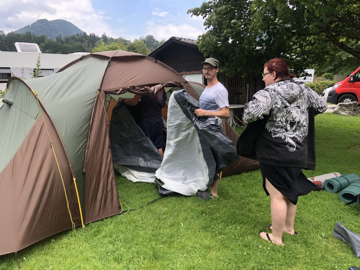 zwei junge Erwachsene beim Zelte aufbauen
