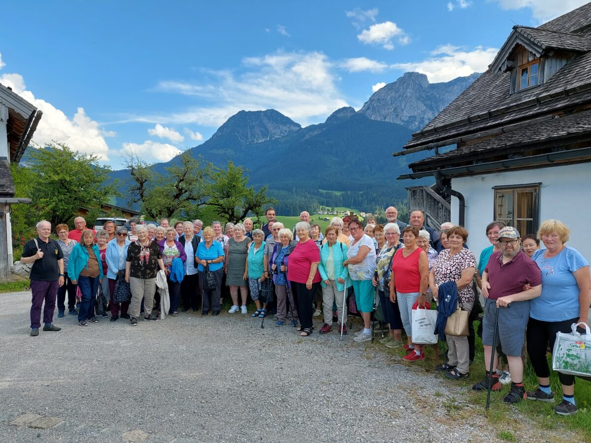Gruppenfoto mit ca. 50 älteren Personen, im Hintergrund Bergpanorama