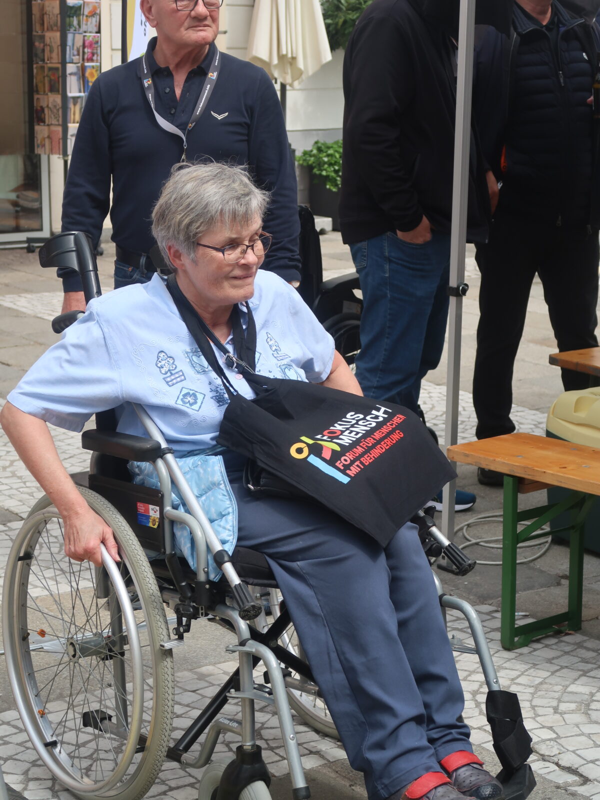 Frau im Rollstuhl mit Fokus Mensch-Stoffsackerl