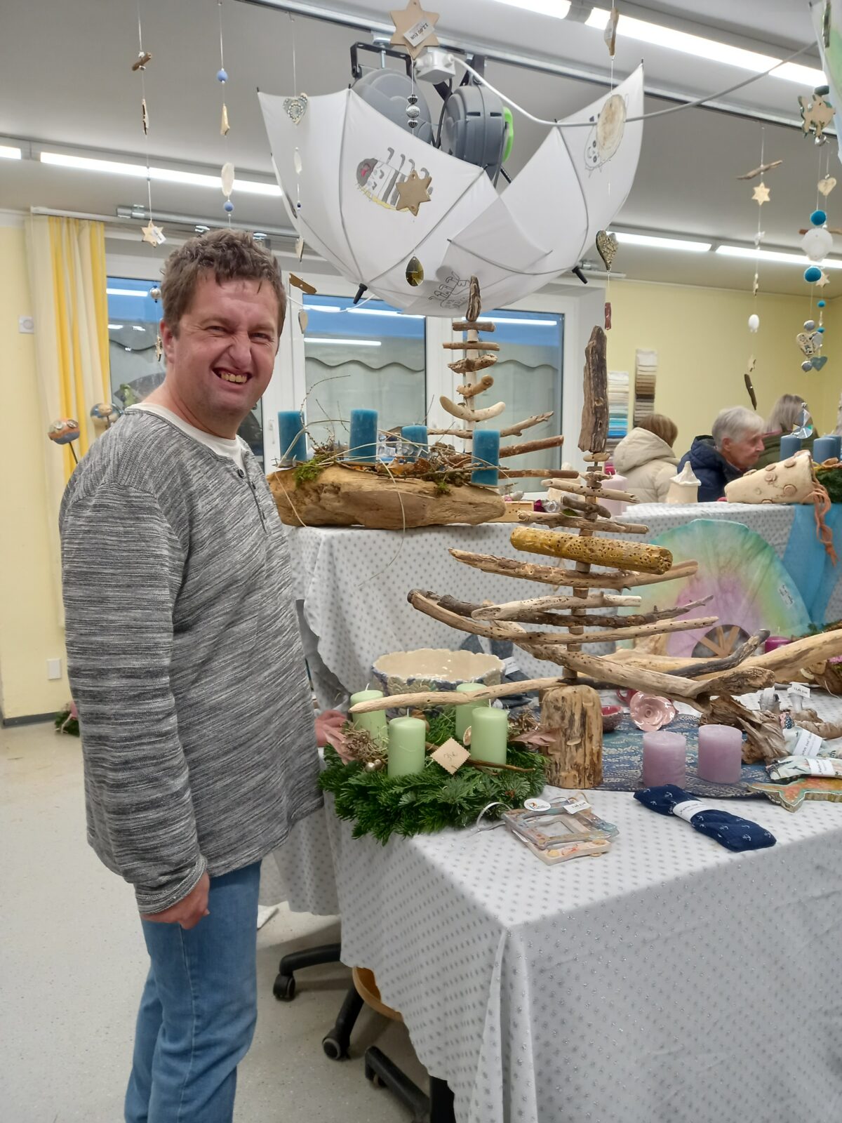 Mann steht in einem Verkaufsraum mit kreativem Kunsthandwerk